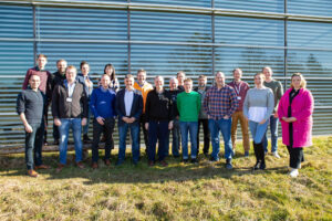 The HammerHAI team standing on the lawn in front of the HLRS building, smiling into the camera.