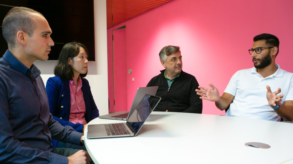 Four people discussing something at a table.
