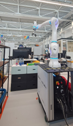 Picture showing a robotic arm in a production hall.